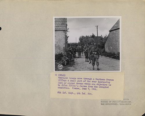 American troops move through a village in Northern France