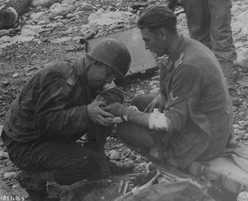 American medical officer treats a wounded German prisoner