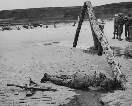 A dead GI lies beside a German Obstacle