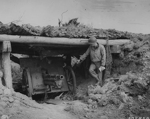 An American soldier examines a 75mm German gun