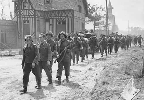 A large party of British troops escort two German prisoners