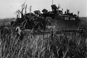 British troops in a camouflaged Bren Carrier