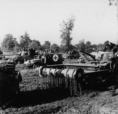 Sherman tanks carrying infantry