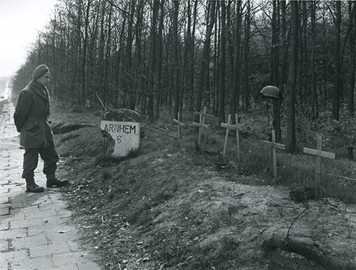 A soldier pauses by temporary graves (BU 4131)