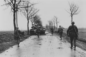 American troops pass a knocked out M24 light tank