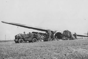 Airborne troops drive a jeep out of a crashed Horsa