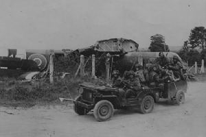 Glider pilots in a trailer being pulled by a jeep