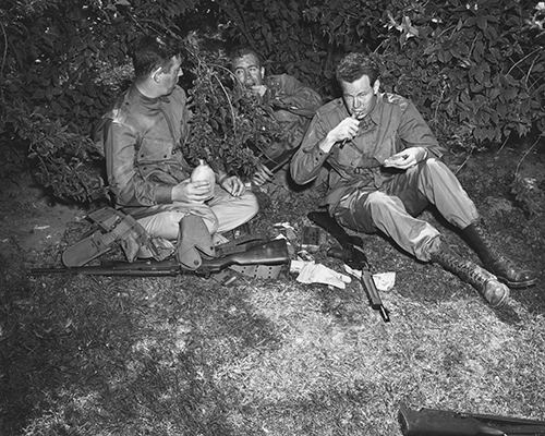 Three Army paratroopers chow down on K rations
