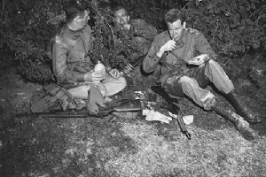Three Army paratroopers chow down on K rations