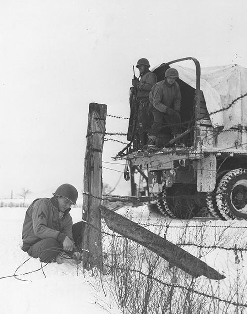 A member of the 4th Armoured Div laying wire