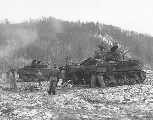 Sherman tanks give supporting fire to 32 Armoured Regiment