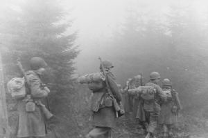American soldiers advance through the forest of Ardennes